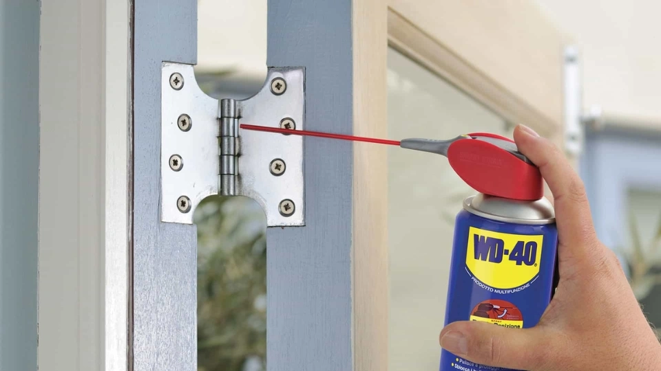 Application de spray lubrifiant sur la crémone d'une fenêtre à Anderlecht pour faciliter la fermeture du châssis dilaté par la chaleur.